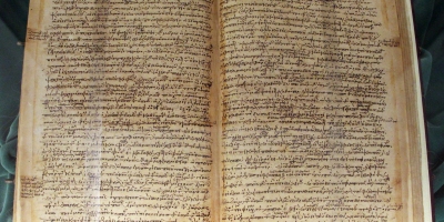 An open ancient book dense with text